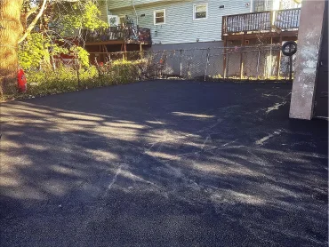 Driveway paving installation crew compacting asphalt in Passaic County NJ